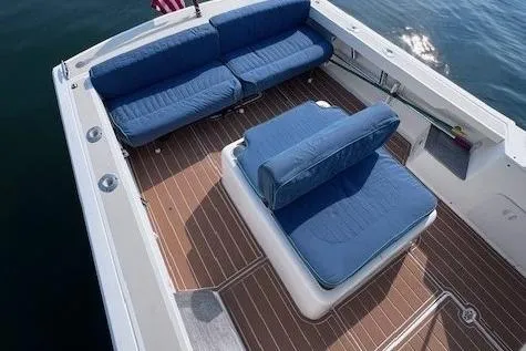 Slide: The Image of 2004 Hunt Yachts Surfhunter 25 deck with blue seating and wooden flooring. - 15