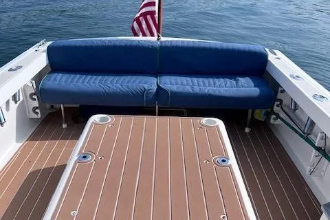 Slide: The Image of 2004 Hunt Yachts Surfhunter 25 with blue seating and American flag on deck. - 16