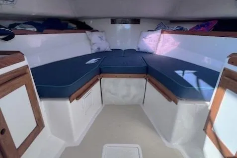 Slide: The Image of 2004 Hunt Yachts Surfhunter 25 cabin interior with blue cushions and wooden accents. - 19