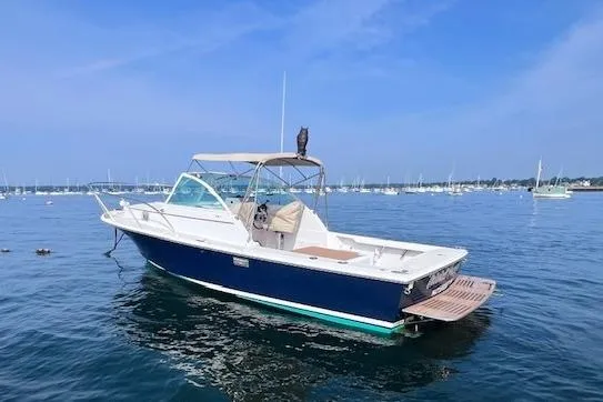 Slide: The Image of 2004 Hunt Yachts Surfhunter 25 boat on calm water with clear blue sky. - 2