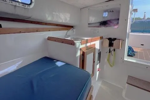 Slide: The Image of Interior of 2004 Hunt Yachts Surfhunter 25 with blue cushioned seating and wooden accents. - 23