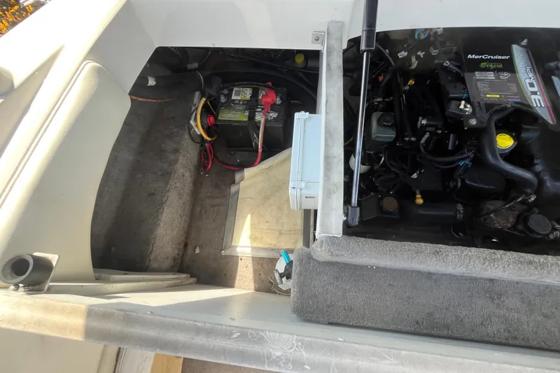 Slide: The Image of 2013 Monterey 184FS boat engine compartment with battery and MerCruiser engine components. - 12