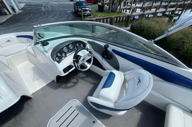 Slide: The Image of 2013 Monterey 184FS boat interior with steering wheel and dashboard, dockside view. - 15