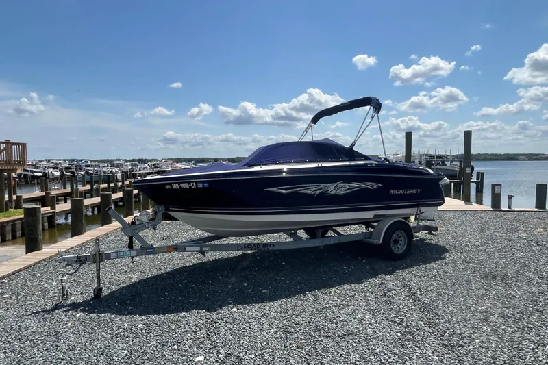 Slide: The Image of 2013 Monterey 184FS boat on trailer by marina under blue sky. - 2