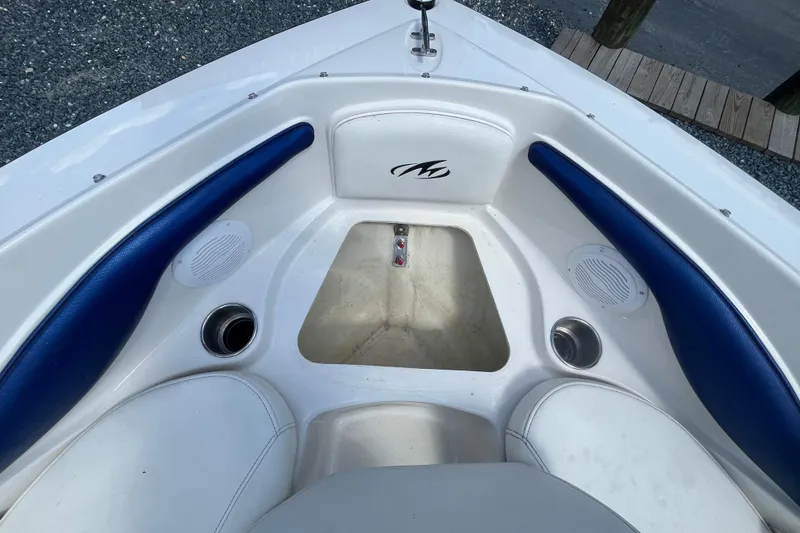 Slide: The Image of 2013 Monterey 184FS boat interior with blue and white seating, cup holders, and speakers. - 21