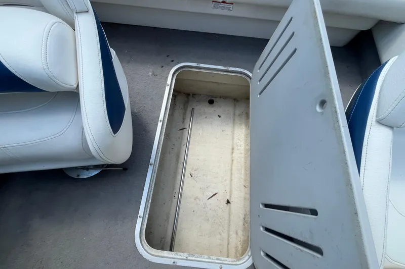 Slide: The Image of Open storage compartment in 2013 Monterey 184FS boat, with white and blue seating. - 23