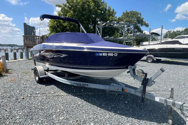 Slide: The Image of 2013 Monterey 184FS boat on trailer, parked outdoors near a marina. - 6