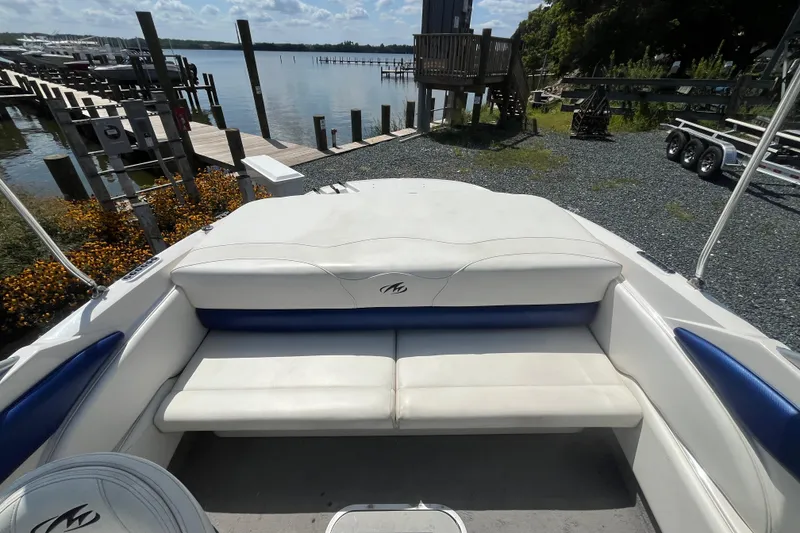 Slide: The Image of 2013 Monterey 184FS boat interior with white and blue seating, dockside view. - 9