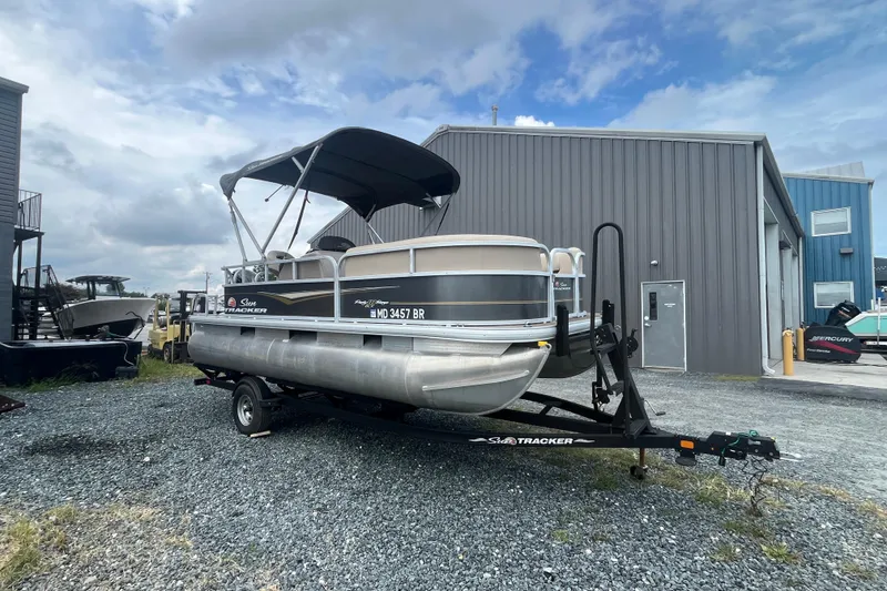 The Image of 2021 Sun Tracker Party Barge 18 DLX pontoon boat on trailer, parked outdoors. - 0