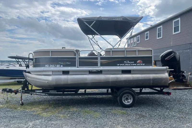 Slide: The Image of 2021 Sun Tracker Party Barge 18 DLX pontoon boat on trailer, parked outdoors. - 3