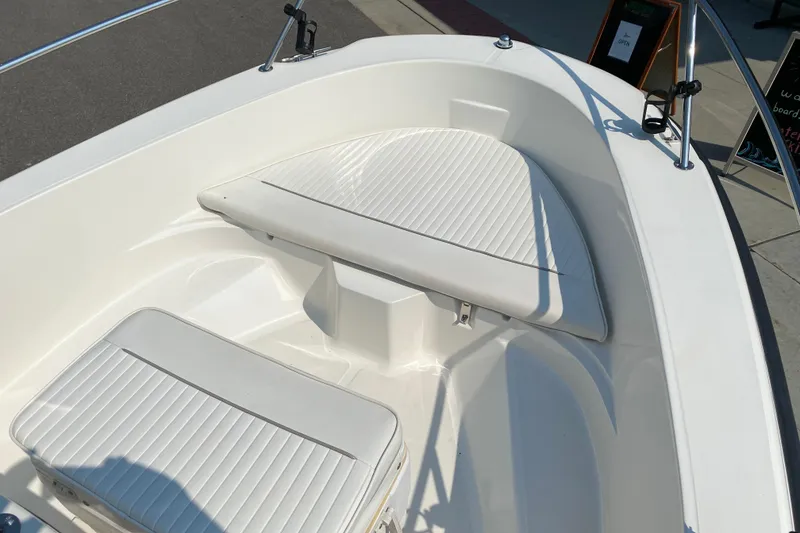 Slide: The Image of 2001 Boston Whaler 18 Dauntless boat interior with white cushioned seating. - 14