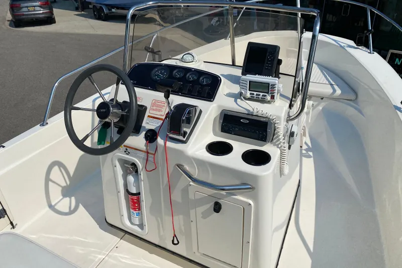Slide: The Image of 2001 Boston Whaler 18 Dauntless boat console with steering wheel and navigation equipment. - 19