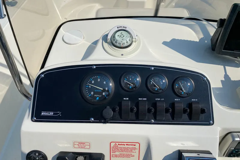 Slide: The Image of Control panel of a 2001 Boston Whaler 18 Dauntless boat with gauges and switches. - 22