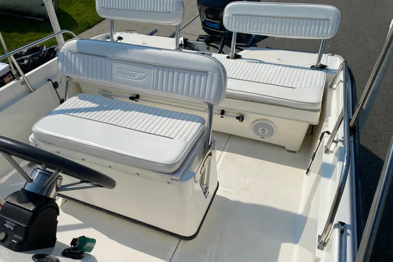 Slide: The Image of 2001 Boston Whaler 18 Dauntless boat interior with white seating and steering wheel. - 29