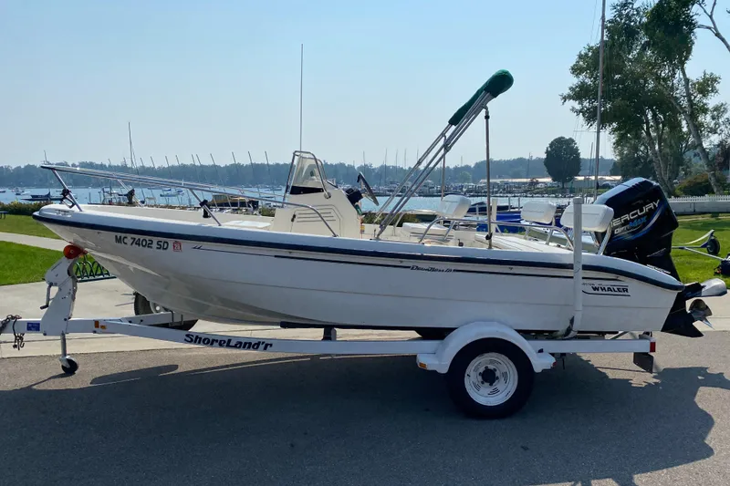 Slide: The Image of 2001 Boston Whaler 18 Dauntless boat on trailer, parked near marina. - 3
