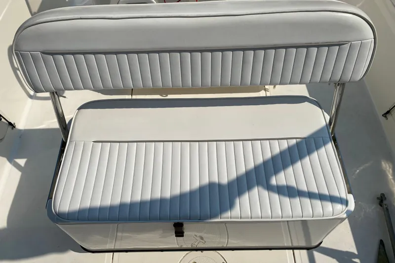 Slide: The Image of Boston Whaler 18 Dauntless 2001 boat seat with white cushioned upholstery. - 32