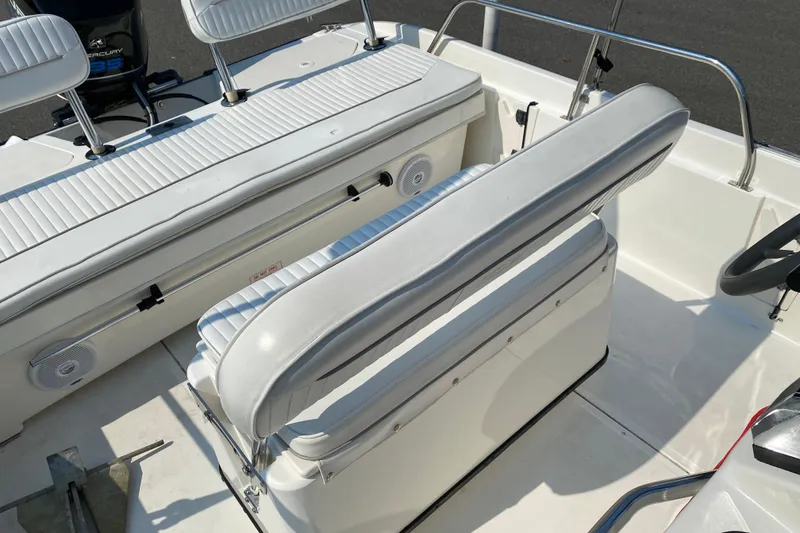 Slide: The Image of 2001 Boston Whaler 18 Dauntless boat interior with white seating and steering wheel. - 33