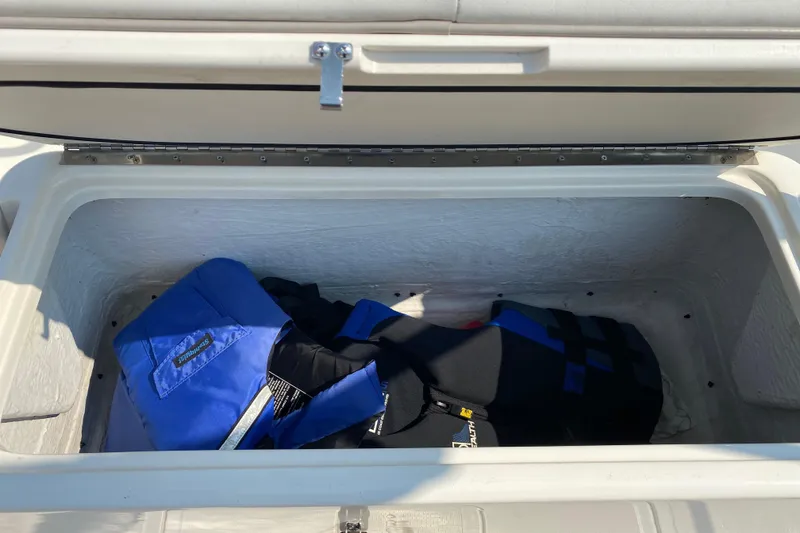 Slide: The Image of Open storage compartment on 2001 Boston Whaler 18 Dauntless with life jackets inside. - 38