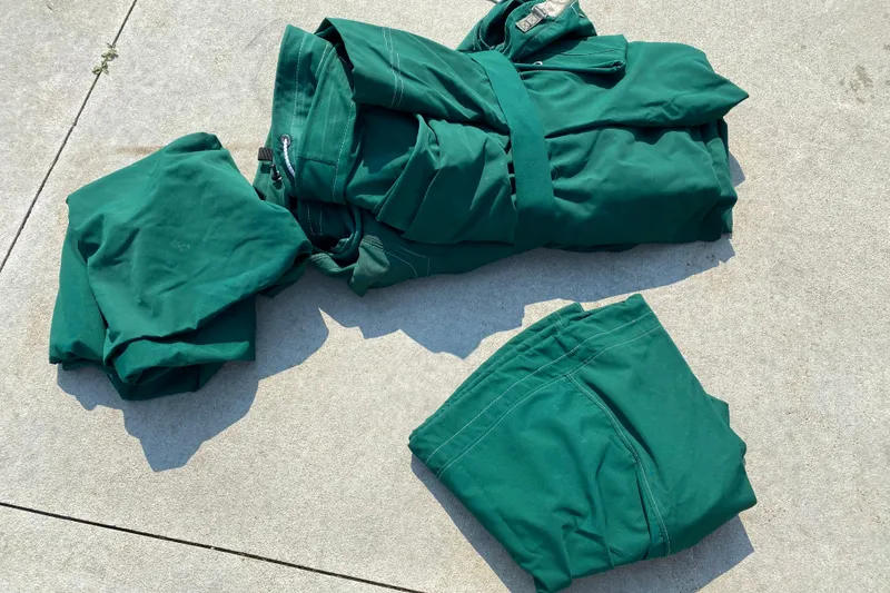 Slide: The Image of Green fabric pieces on concrete, possibly boat cover for 2001 Boston Whaler 18 Dauntless. - 45