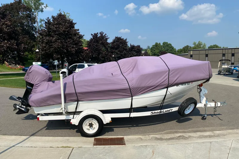 Slide: The Image of 2001 Boston Whaler 18 Dauntless boat covered on trailer, parked outdoors. - 47