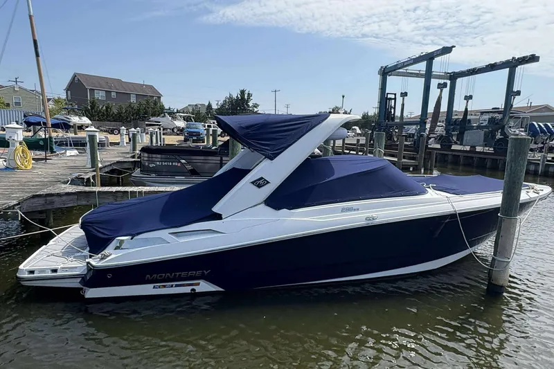 The Image of 2017 Monterey 298SS boat docked at a marina, covered with a blue tarp. - 1
