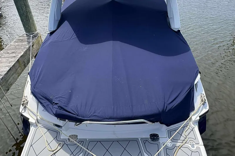 Slide: The Image of 2017 Monterey 298SS boat with blue cover docked on calm water. - 2