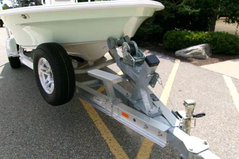 Slide: The Image of 2026 Mako 18 Pro Skiff on trailer, parked on asphalt with greenery background. - 2
