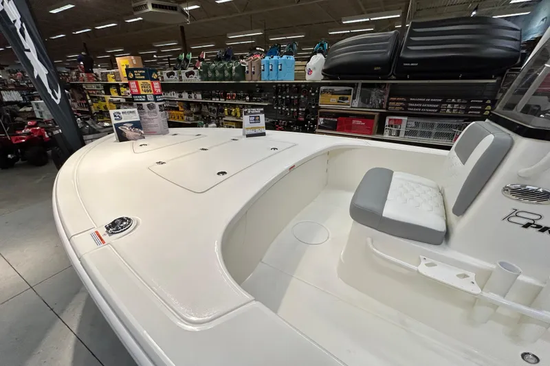 Slide: The Image of 2026 Mako 18 Pro Skiff boat displayed in a showroom with accessories. - 4