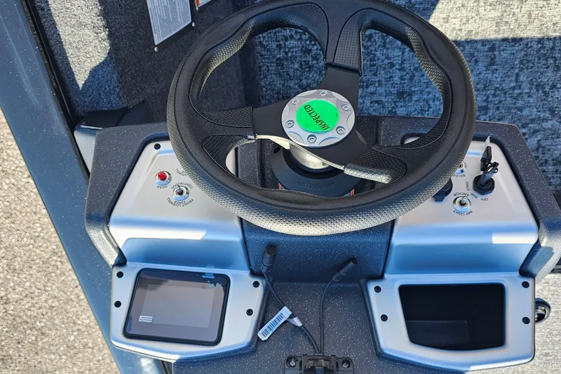 Slide: The Image of Steering console of 2026 Tracker Pro Team 175 Crappie Edition boat, featuring controls and display. - 11