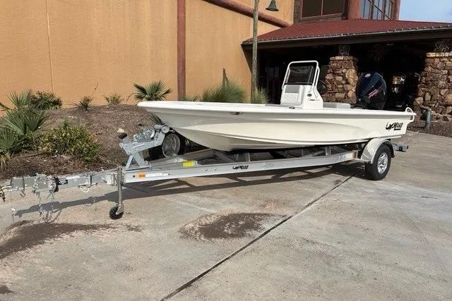 The Image of 2026 Mako 18 Pro Skiff boat on trailer, parked outdoors near a building. - 0
