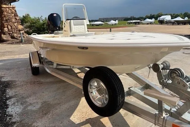 Slide: The Image of 2026 Mako 18 Pro Skiff on trailer, parked outdoors, showcasing sleek design and sturdy build. - 3