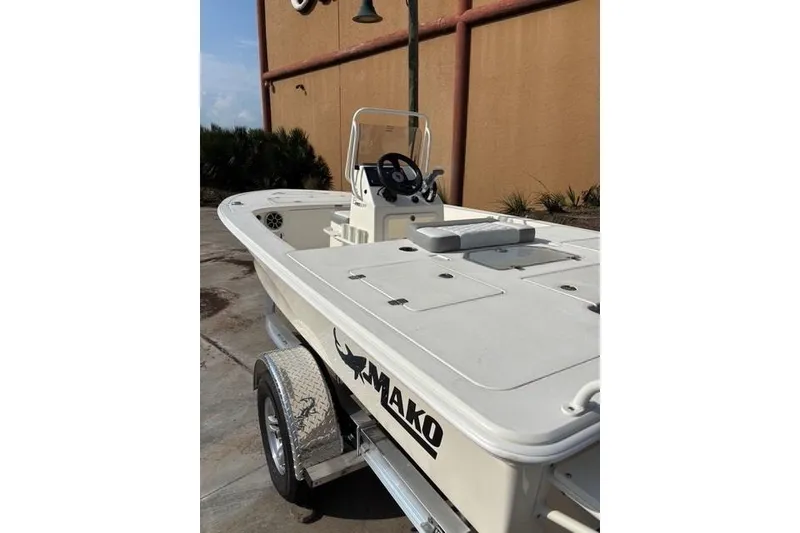 Slide: The Image of 2026 Mako 18 Pro Skiff boat on trailer, parked outdoors. - 4