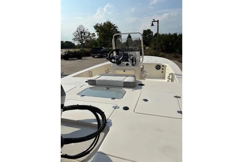 Slide: The Image of 2026 Mako 18 Pro Skiff boat with console and seating, parked outdoors. - 8