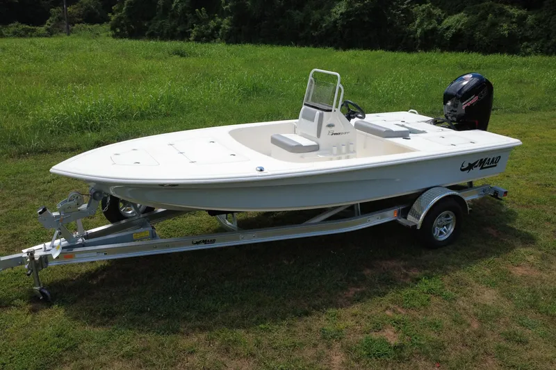 The Image of 2026 Mako Pro Skiff 18 boat on trailer, parked on grassy field. - 0
