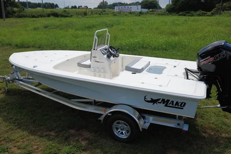 Slide: The Image of 2026 Mako 18 Pro Skiff boat on trailer, parked on grassy field. - 2