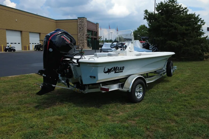 Slide: The Image of 2026 Mako 18 Pro Skiff boat on trailer, parked on grass near a building. - 9