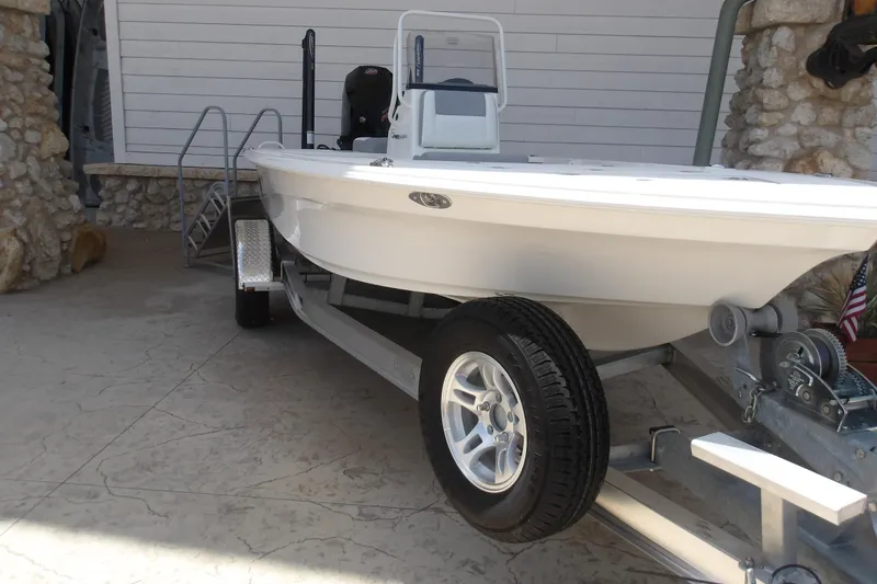 Slide: The Image of 2026 Mako 18 Pro Skiff on trailer, parked near stone wall. - 3