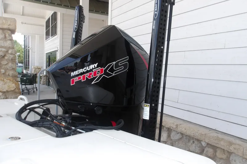 Slide: The Image of Mercury Pro XS engine on 2026 Mako 18 Pro Skiff boat, docked near a building. - 13