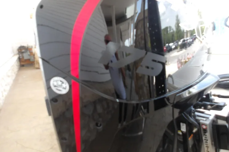 Slide: The Image of Close-up of a 2026 Mako 18 Pro Skiff boat engine with red stripe detailing. - 8