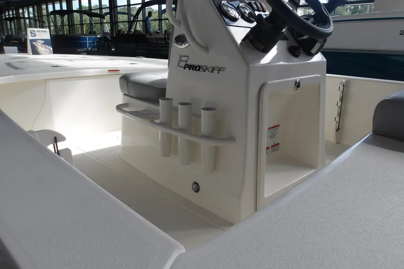 Slide: The Image of 2026 Mako 18 Pro Skiff boat interior with steering console and rod holders. - 13