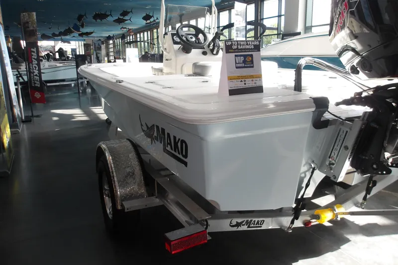 Slide: The Image of 2026 Mako 18 Pro Skiff boat displayed indoors on a trailer. - 9