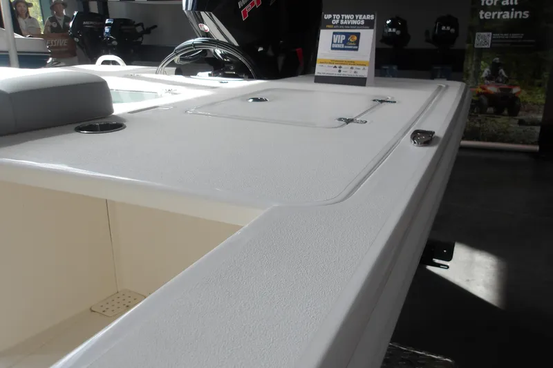 Slide: The Image of 2026 Mako 18 Pro Skiff boat deck with storage compartments and promotional sign. - 16