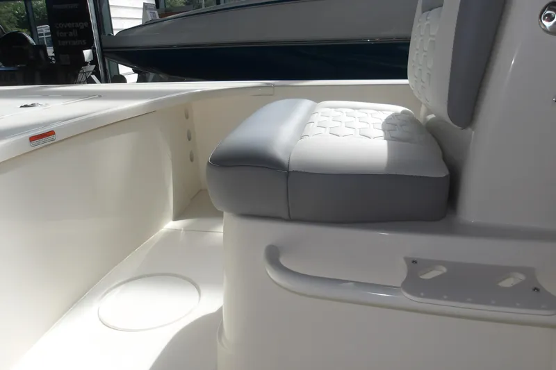 Slide: The Image of Interior view of 2026 Mako 18 Pro Skiff boat, featuring cushioned seating and sleek design. - 14