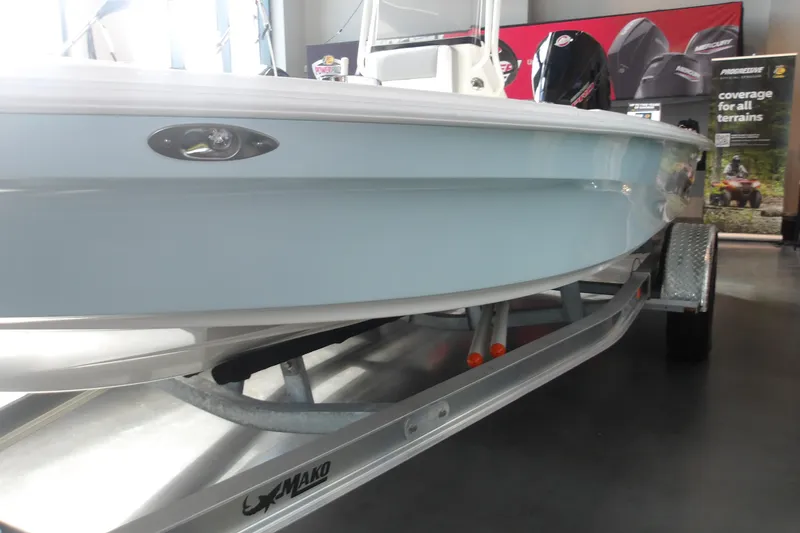Slide: The Image of 2026 Mako 18 Pro Skiff boat on trailer, displayed indoors. - 2
