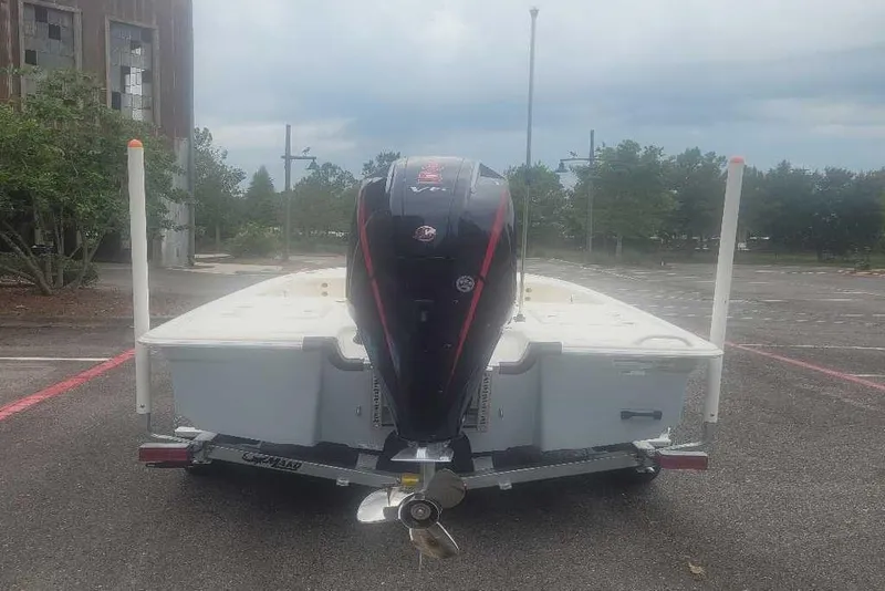 Slide: The Image of 2026 Mako 18 Pro Skiff boat on trailer, rear view in parking lot. - 2
