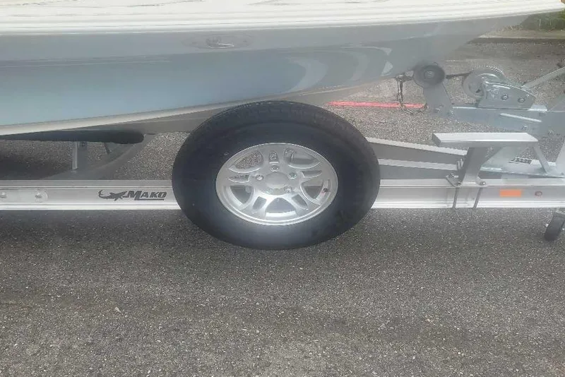 Slide: The Image of 2026 Mako 18 Pro Skiff on trailer, showcasing wheel and hull details. - 5