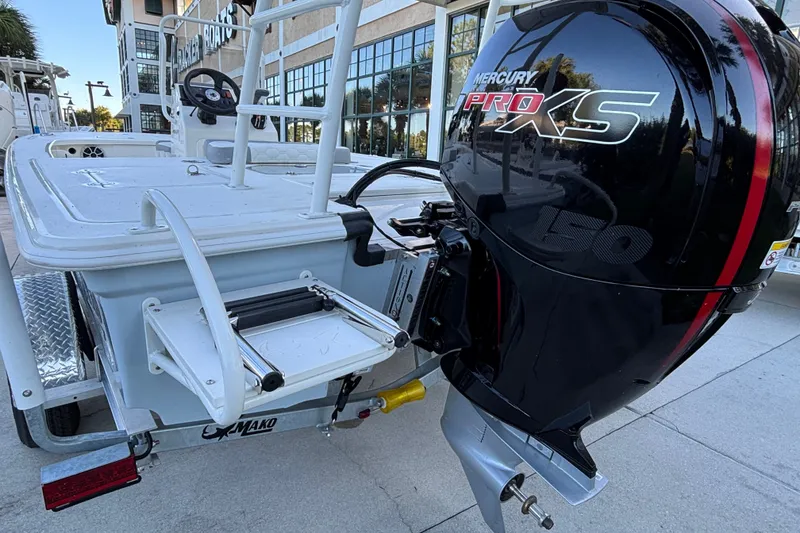 Slide: The Image of 2026 Mako 18 Pro Skiff with Mercury Pro XS 150 engine, parked outdoors. - 3