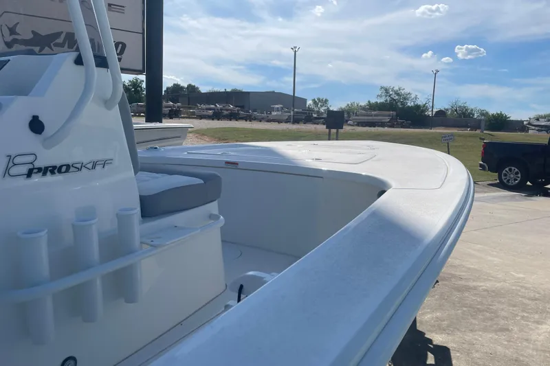 Slide: The Image of 2026 Mako 18 Pro Skiff boat, white interior, parked outdoors under a blue sky. - 6