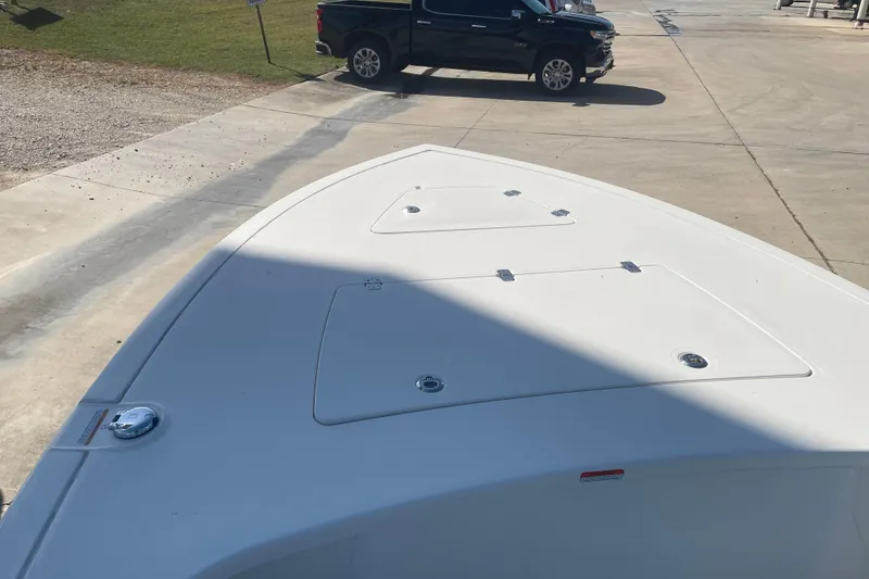 Slide: The Image of Bow of 2026 Mako 18 Pro Skiff boat on concrete surface, with parked truck nearby. - 8