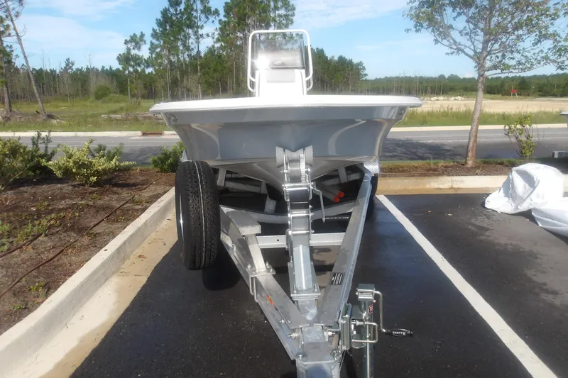 Slide: The Image of 2026 Mako 18 Pro Skiff boat on trailer in parking lot, surrounded by trees. - 3